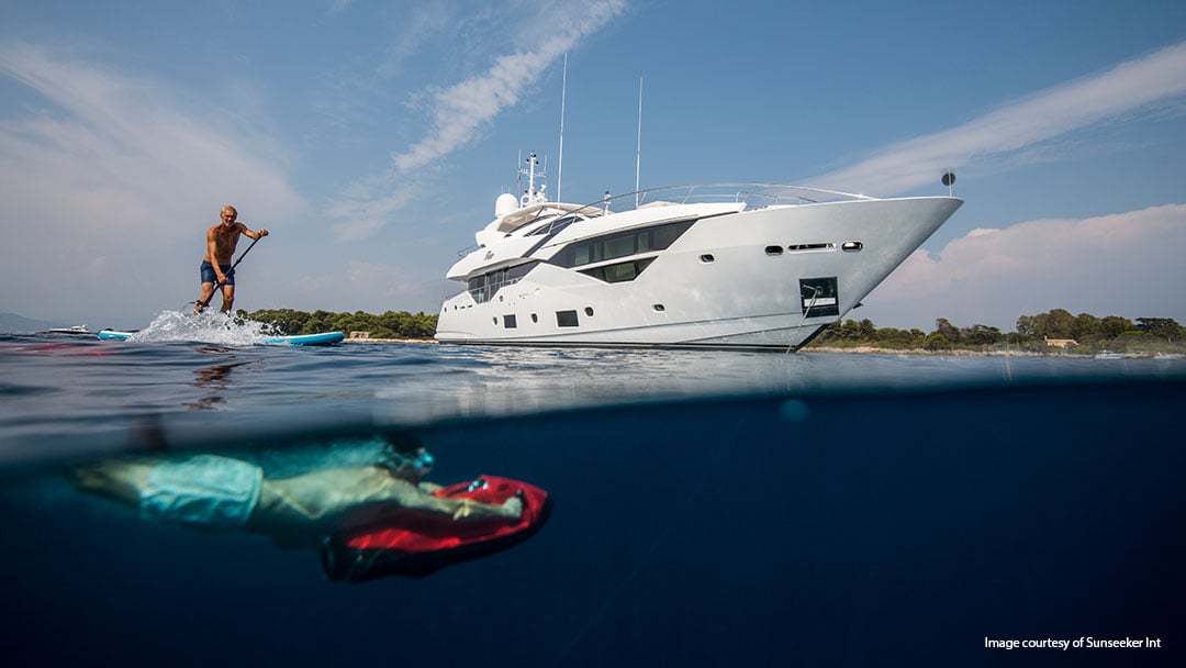 People playing in the water next to a sunseeker with vector fins stabilizers